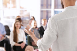 An image of a man presenting to a room full of people